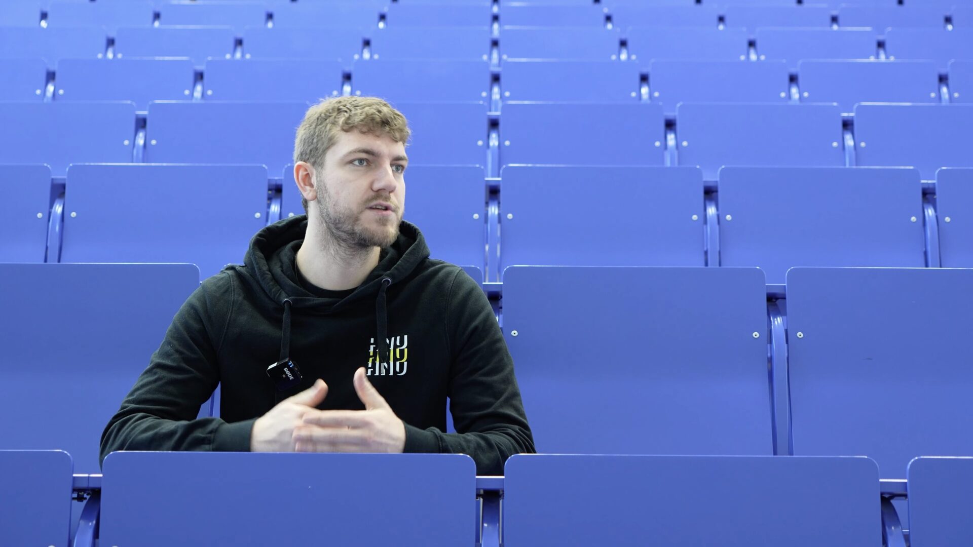 Person im HNU-Hoodie sitzt im Hörsaal der Hochschule Neu-Ulm