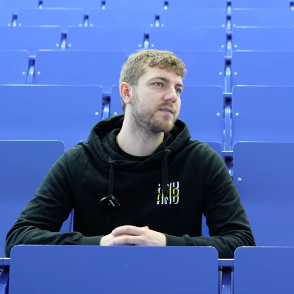 Person im HNU-Hoodie sitzt im Hörsaal der Hochschule Neu-Ulm